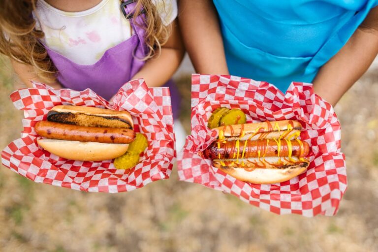 kids holding two hot dogs.