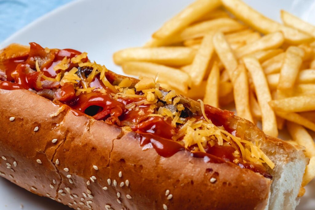 close-up of a loaded hot dog with fries on the side