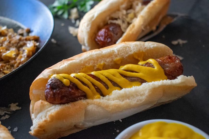 classic hot dogs with mustard on top of them