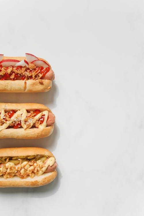 hotdogs placed against a white surface