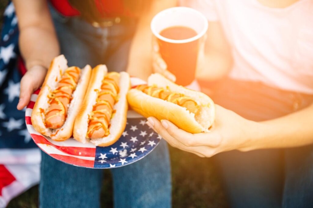 multiple individuals enjoying their hot dogs and drinks