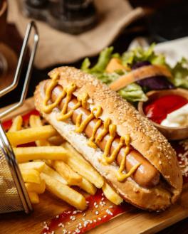 a closeup shot of a loaded hotdog with fries